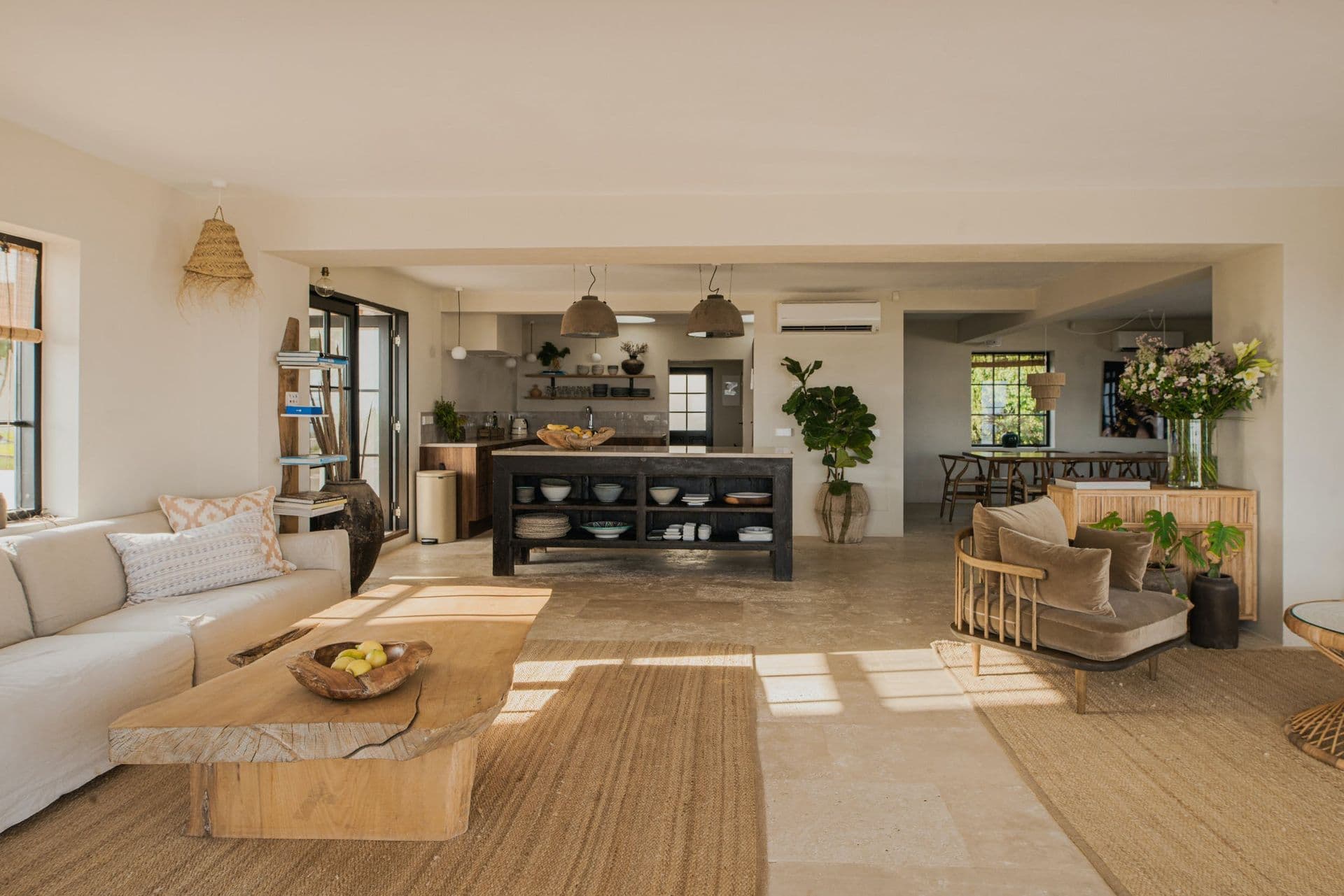 Open plan living and kitchen space with woven rugs and natural linen sofas at New Beat