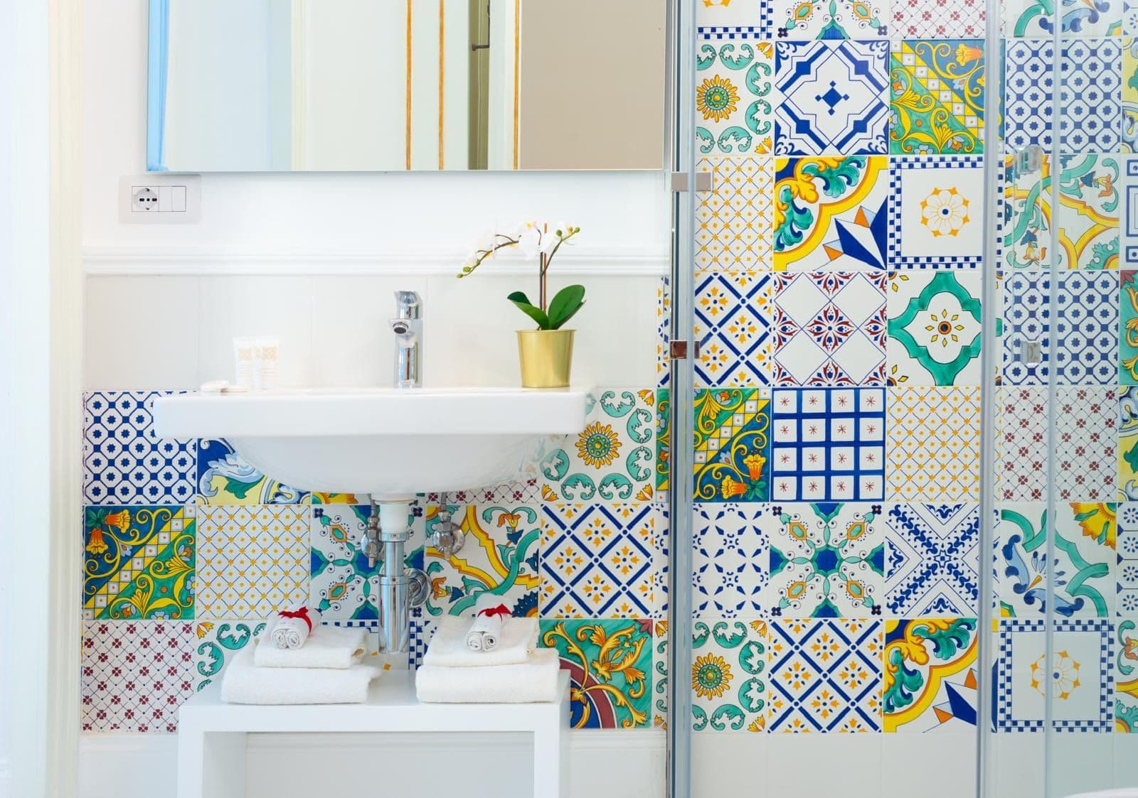 Bathroom sink set against a wall of colourful majolica tiles