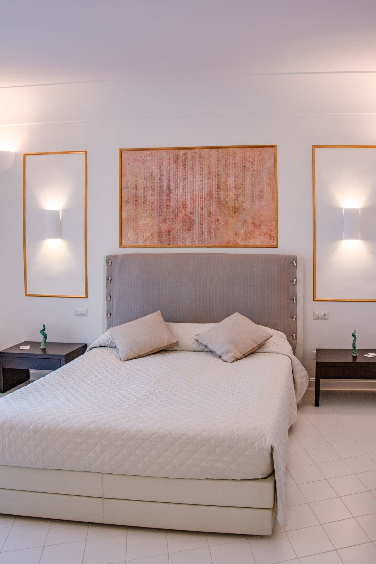 Simply furnished double bedroom with beige upholstered headboard