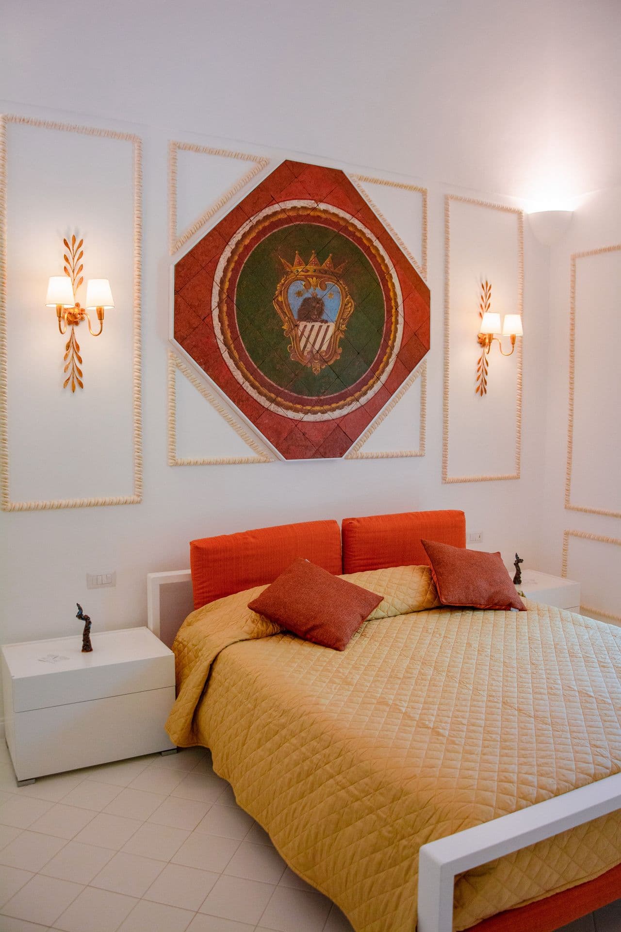 Bedroom with terracotta and orange accent cushions on a white bed