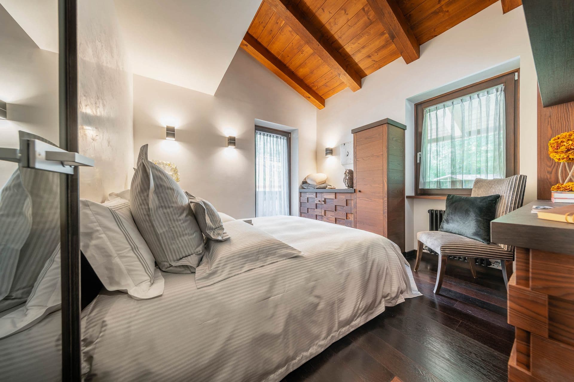 Double bedroom with timber beams and a study corner at Dolomite Prestige, Cortina d'Ampezzo