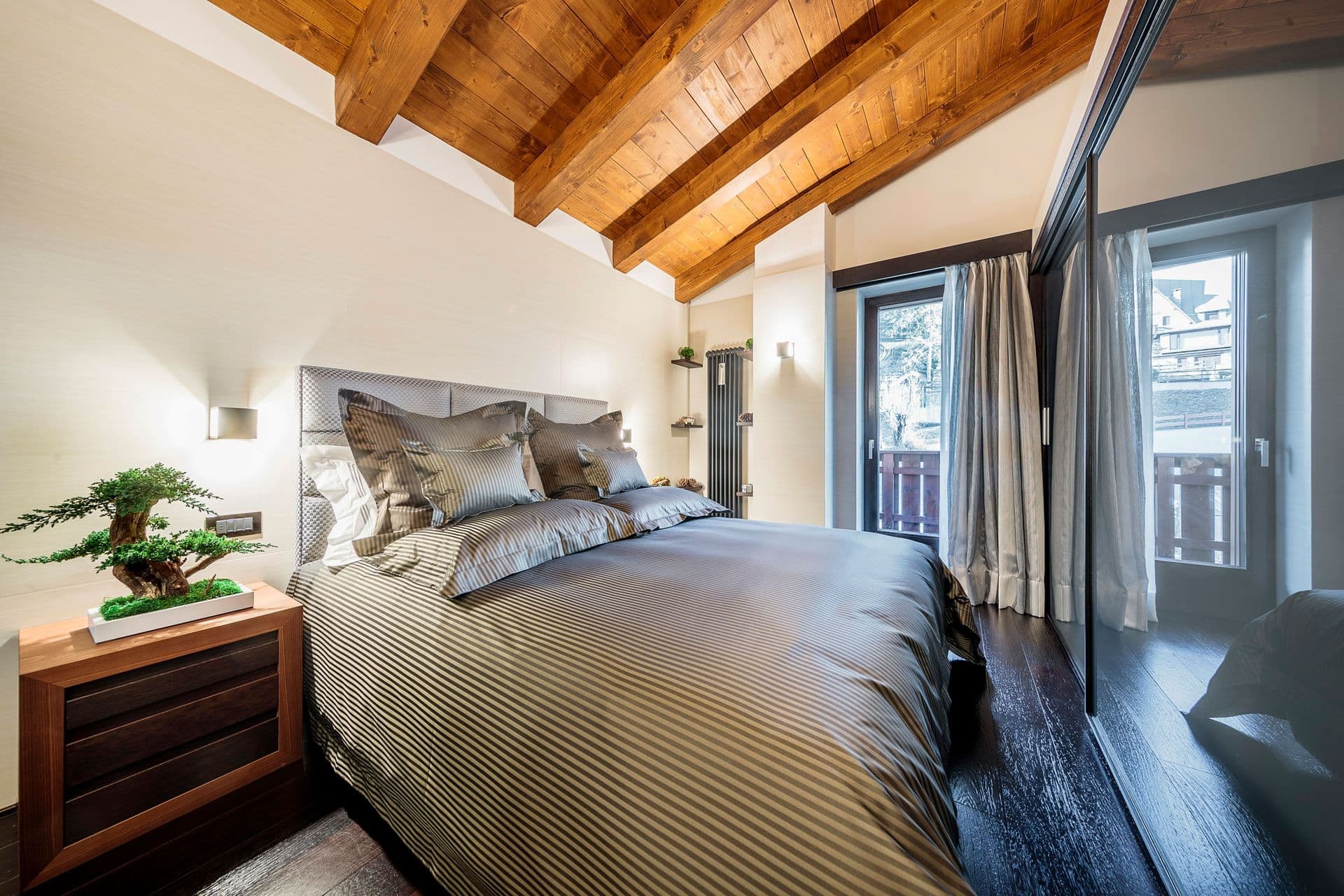 Double bedroom in grey with exposed timber beams at Dolomite Prestige, Cortina d'Ampezzo