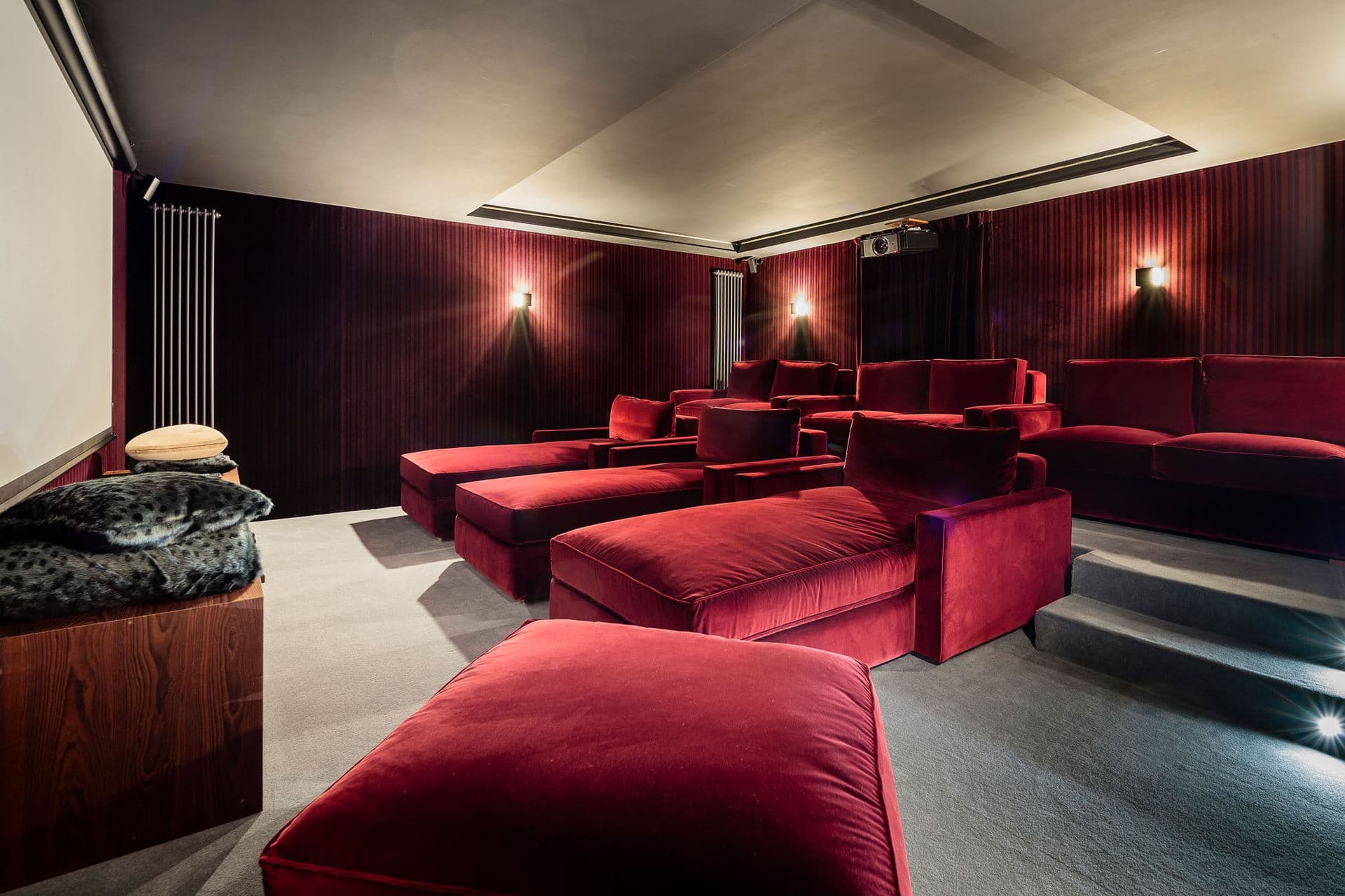 Home cinema with red velvet loungers and dark panelling at Dolomite Prestige, Cortina d'Ampezzo