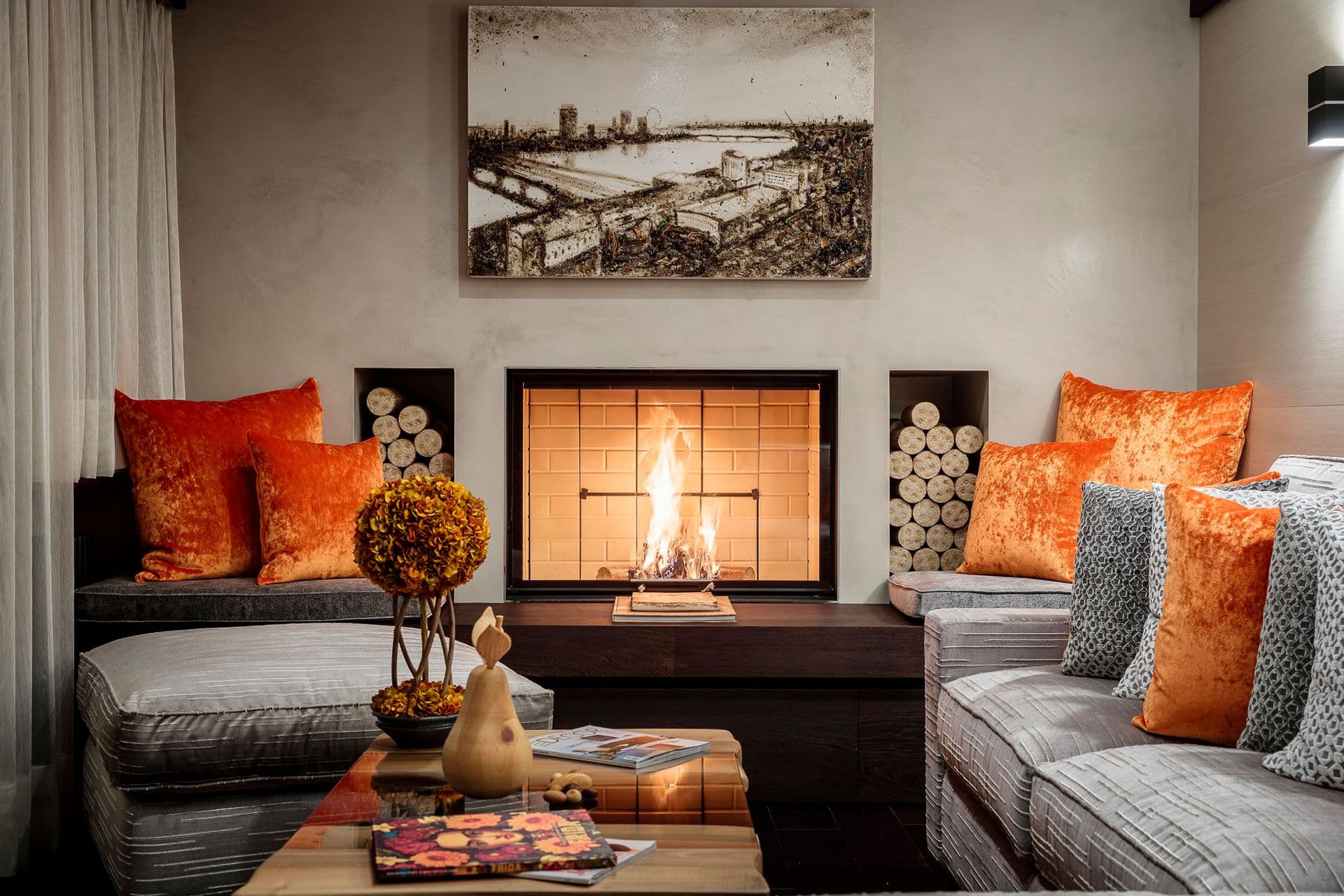 Fireside seating with a wood-burning fireplace and orange accents at Dolomite Prestige, Cortina d'Ampezzo