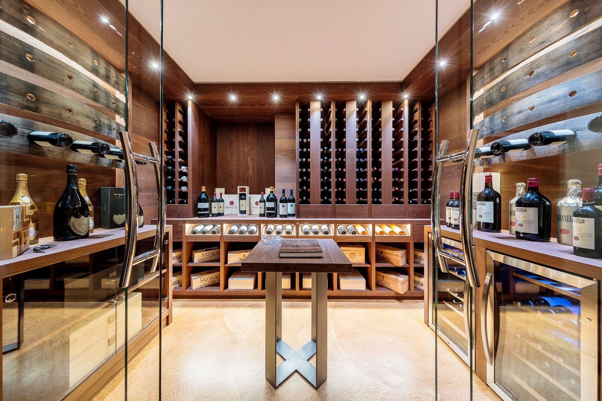 Wine cellar with a tasting table and glass-fronted racks at Dolomite Prestige, Cortina d'Ampezzo