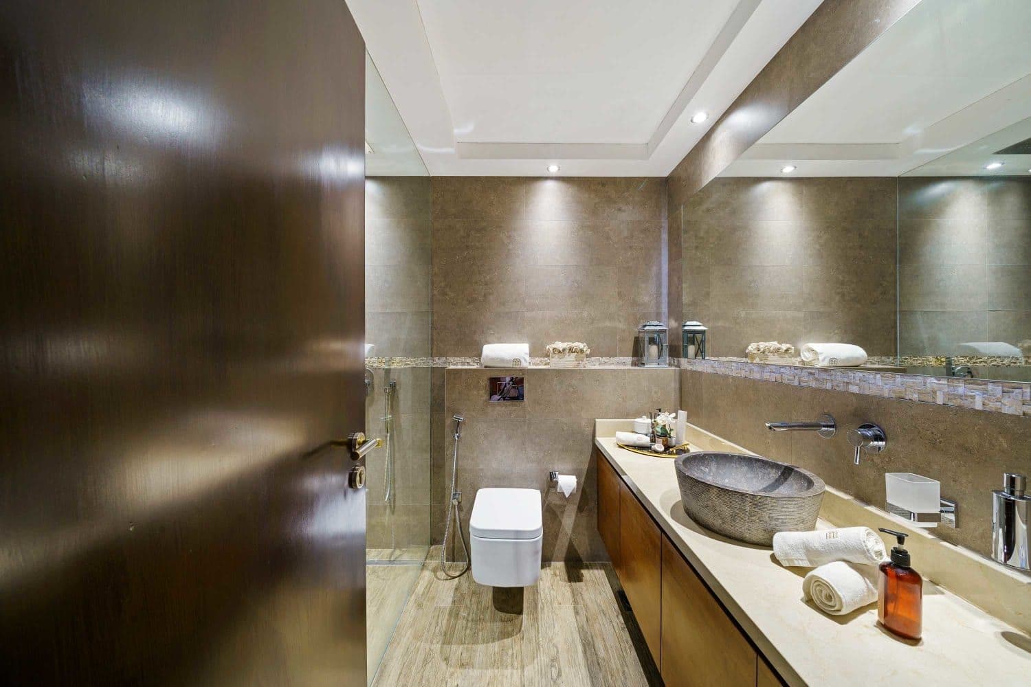 En-suite bathroom with a carved stone basin and walk-in shower at A Place in the Palms, Palm Jumeirah