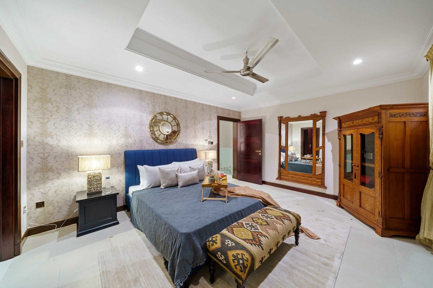 Double bedroom with a navy bed and a carved wooden armoire at A Place in the Palms, Palm Jumeirah