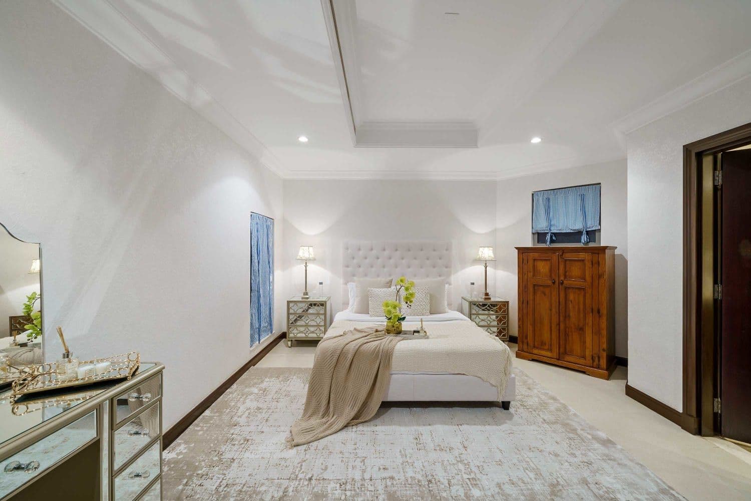 Double bedroom with a white tufted headboard and mirrored bedside tables at A Place in the Palms, Palm Jumeirah