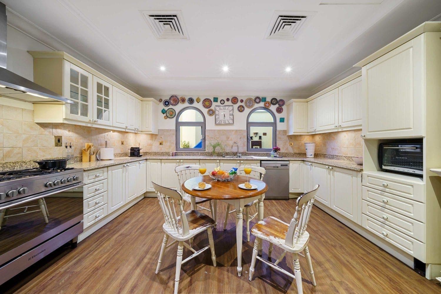 Cream family kitchen with a range cooker and a round breakfast table at A Place in the Palms, Palm Jumeirah