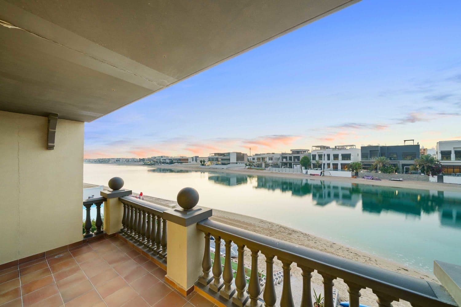 Balcony over a private beach and turquoise lagoon at dusk at A Place in the Palms, Palm Jumeirah, Dubai