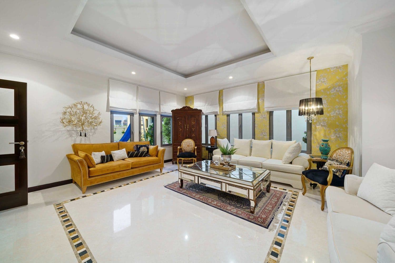 Formal living room with mustard sofas, marble floors and a chandelier at A Place in the Palms, Palm Jumeirah