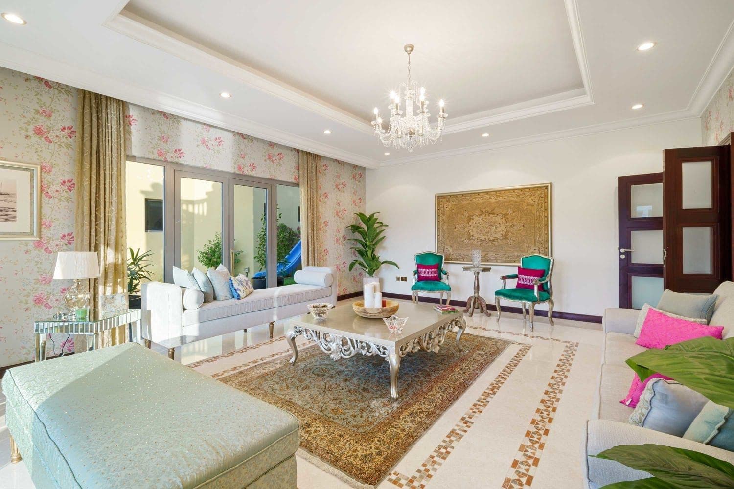 Reception room with a mirrored coffee table and jewel-toned chairs at A Place in the Palms, Palm Jumeirah