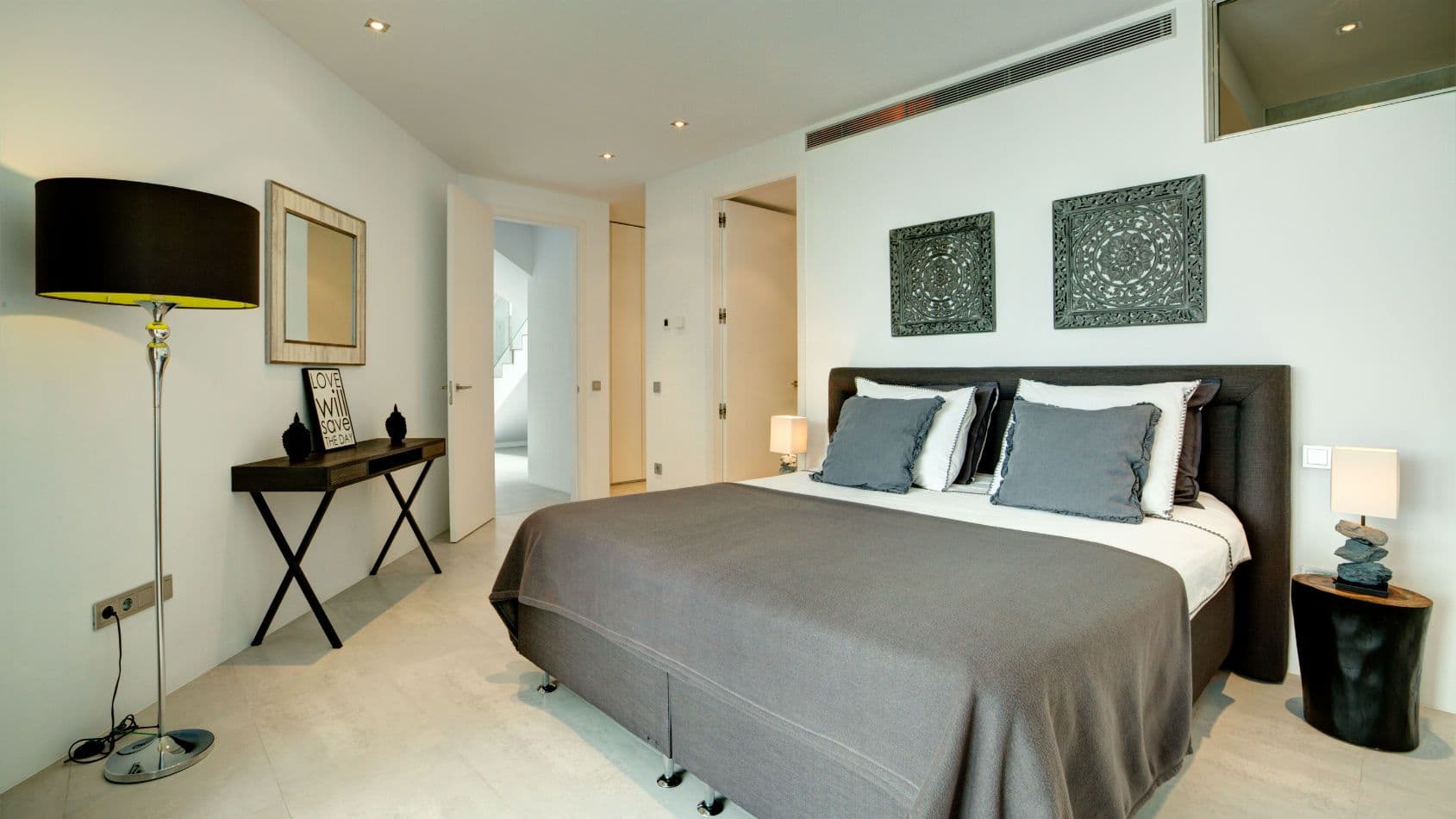 Double bedroom with a sculptural console and carved wall art at Baby, You Can Drive My Car, Ibiza