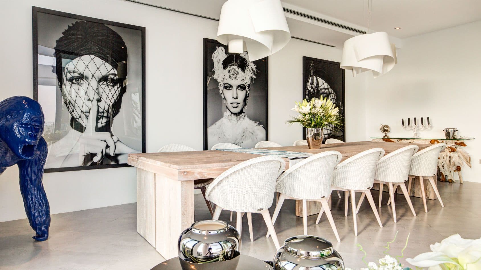 Dining room with a long table and monochrome portrait art at Baby, You Can Drive My Car, Ibiza