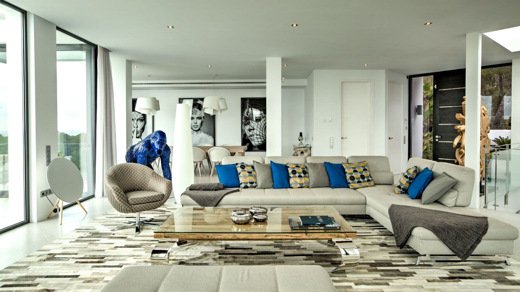 Open living room with grey sofas, pop art and floor-to-ceiling glass at Baby, You Can Drive My Car, Ibiza