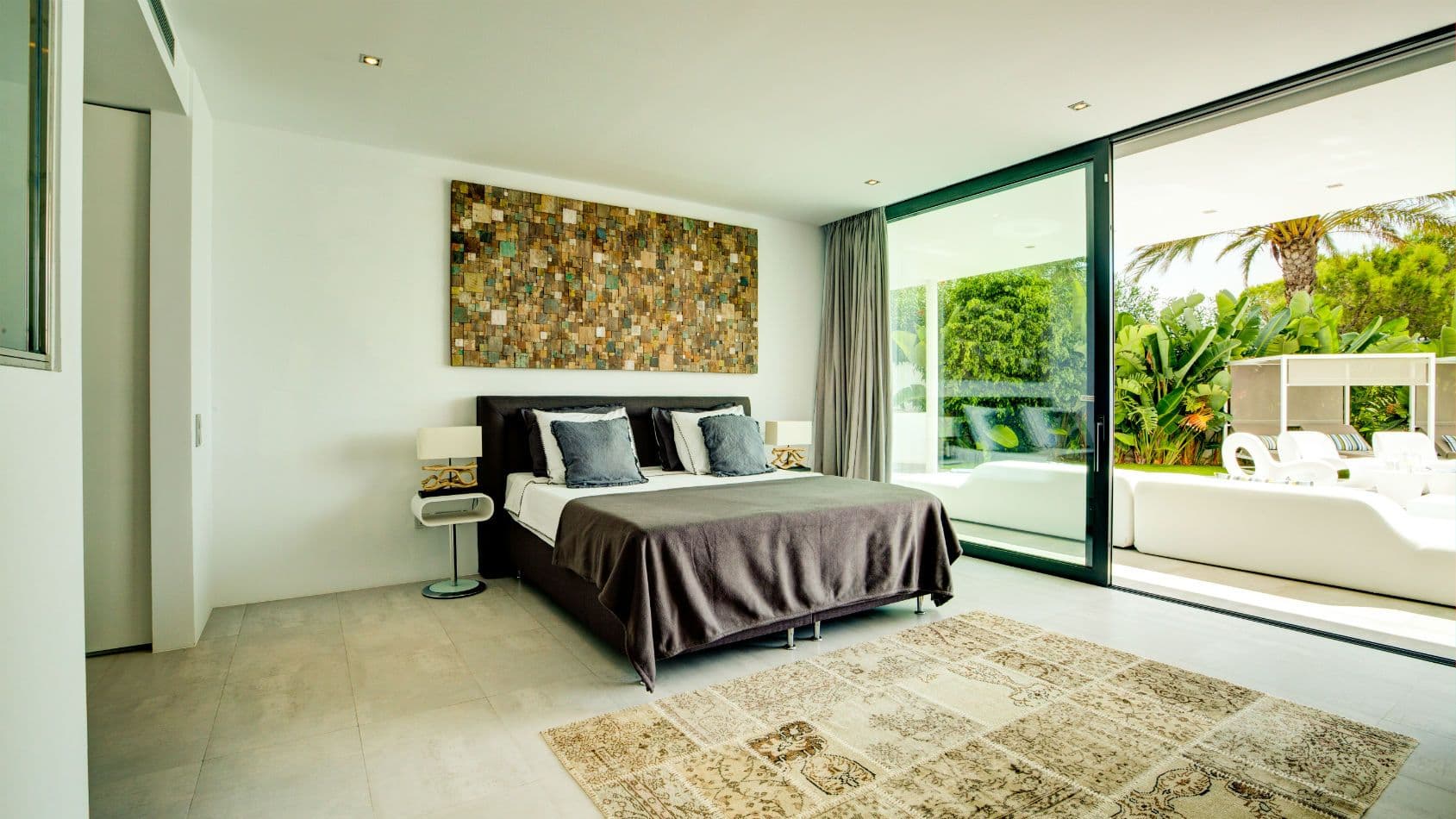 Master bedroom opening through sliding glass to the pool terrace at Baby, You Can Drive My Car, Ibiza