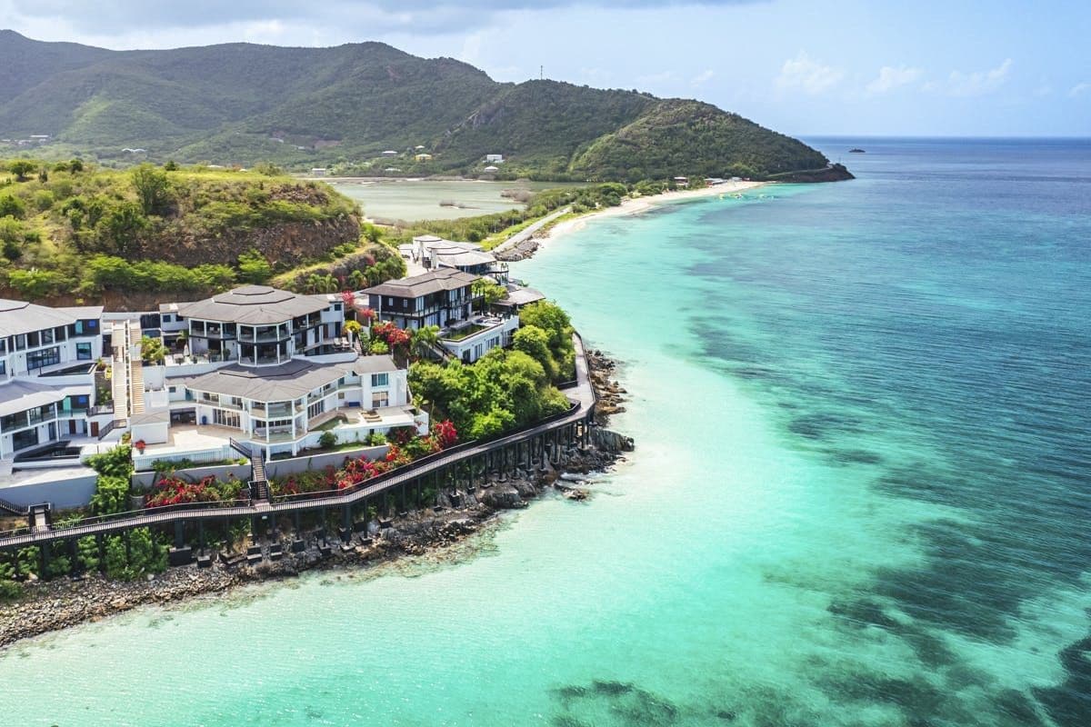 Aerial view of the hillside resort above a turquoise bay at Hills of Antigua