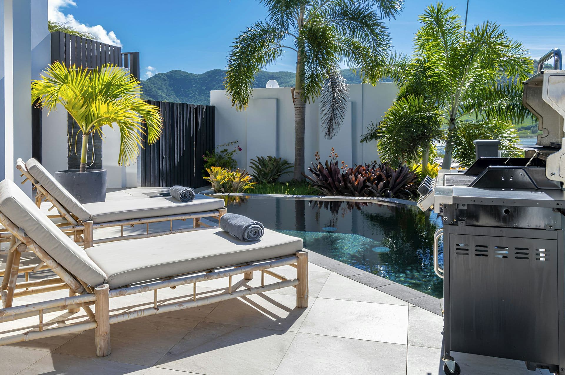 Poolside loungers and a barbecue on the terrace at Hills of Antigua