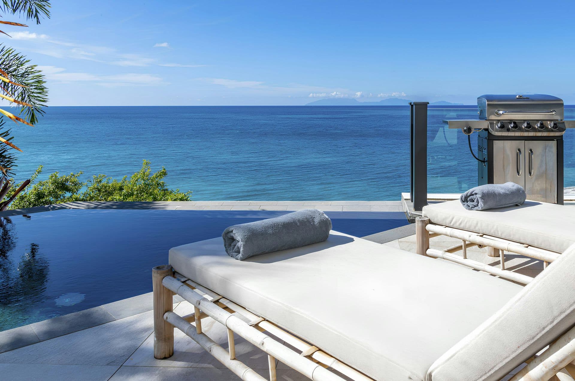 Daybed beside the infinity pool with sea views at Hills of Antigua