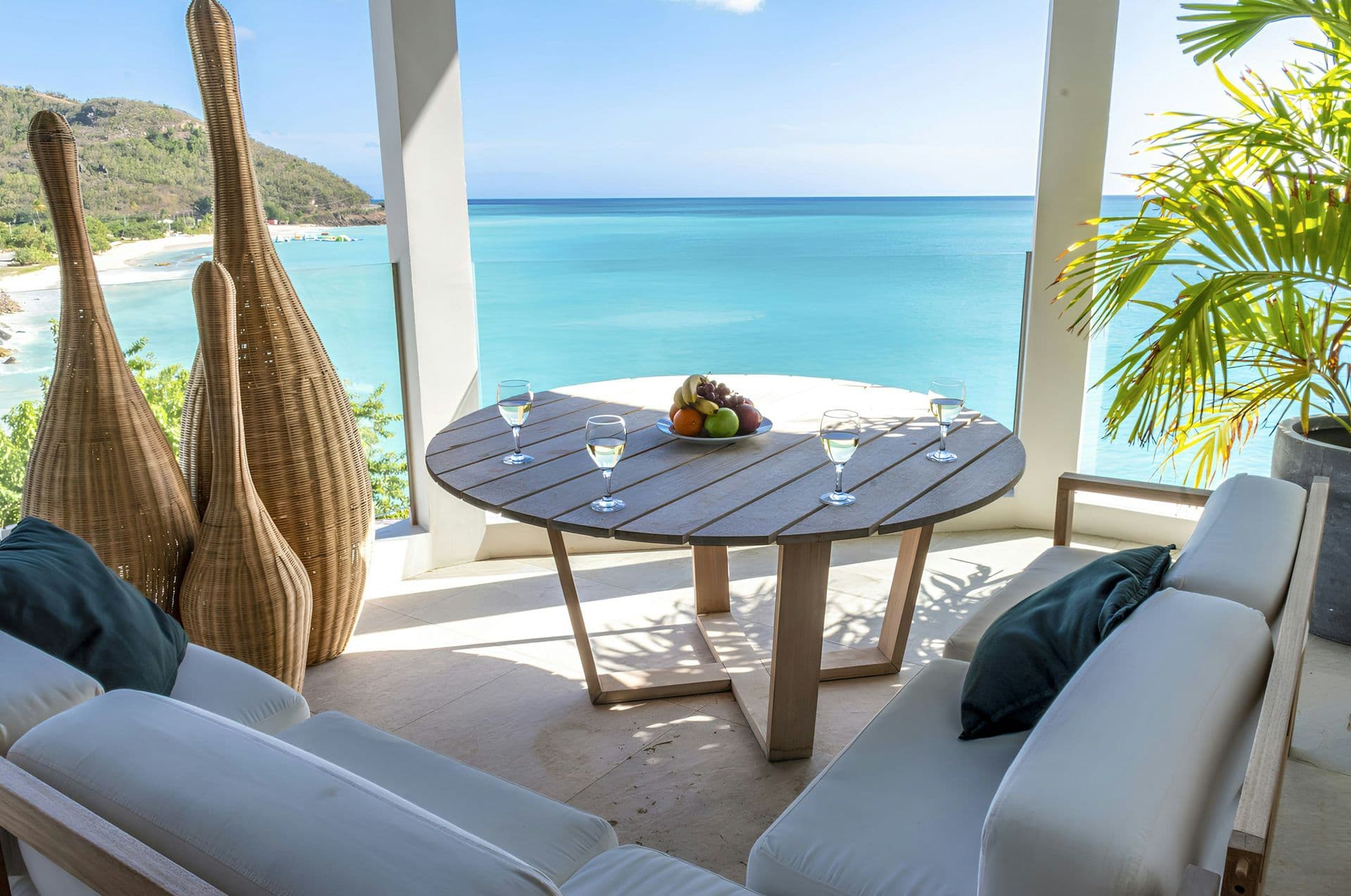 Shaded terrace lounge and dining area with sea views at Hills of Antigua