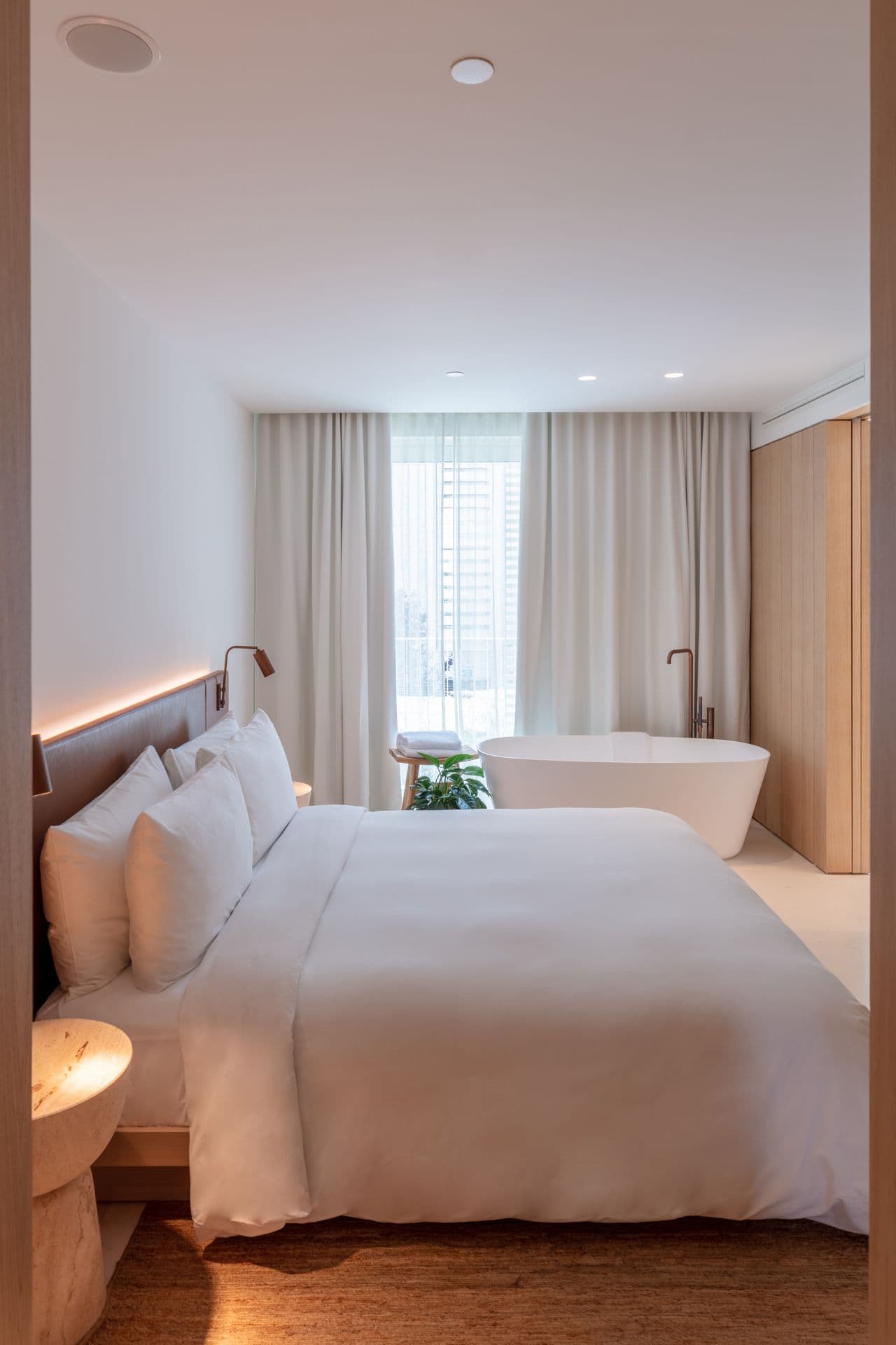 Guest bedroom with crisp white linen and warm wood headboard