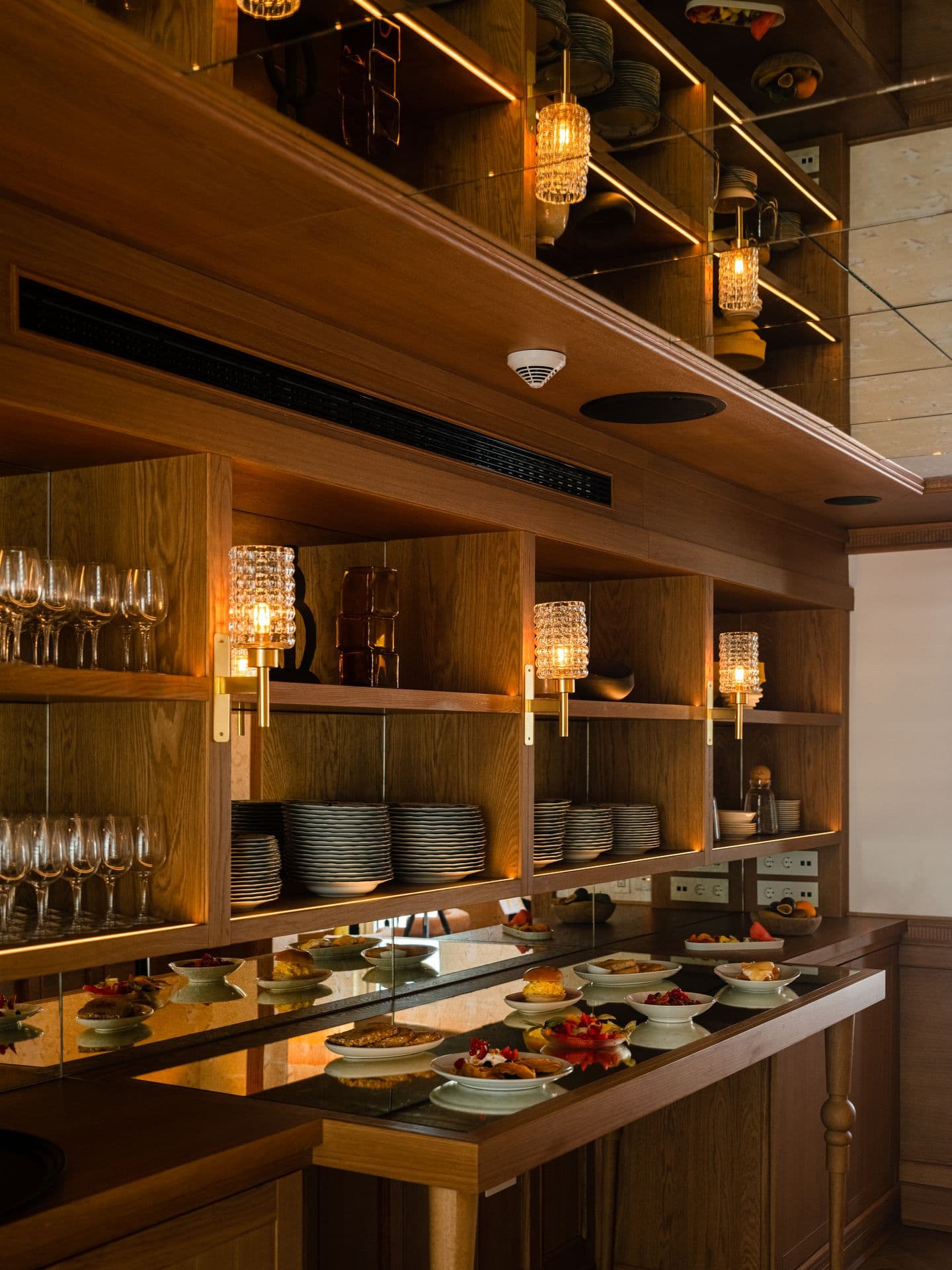 Open bar counter with glassware shelving and pendant lighting