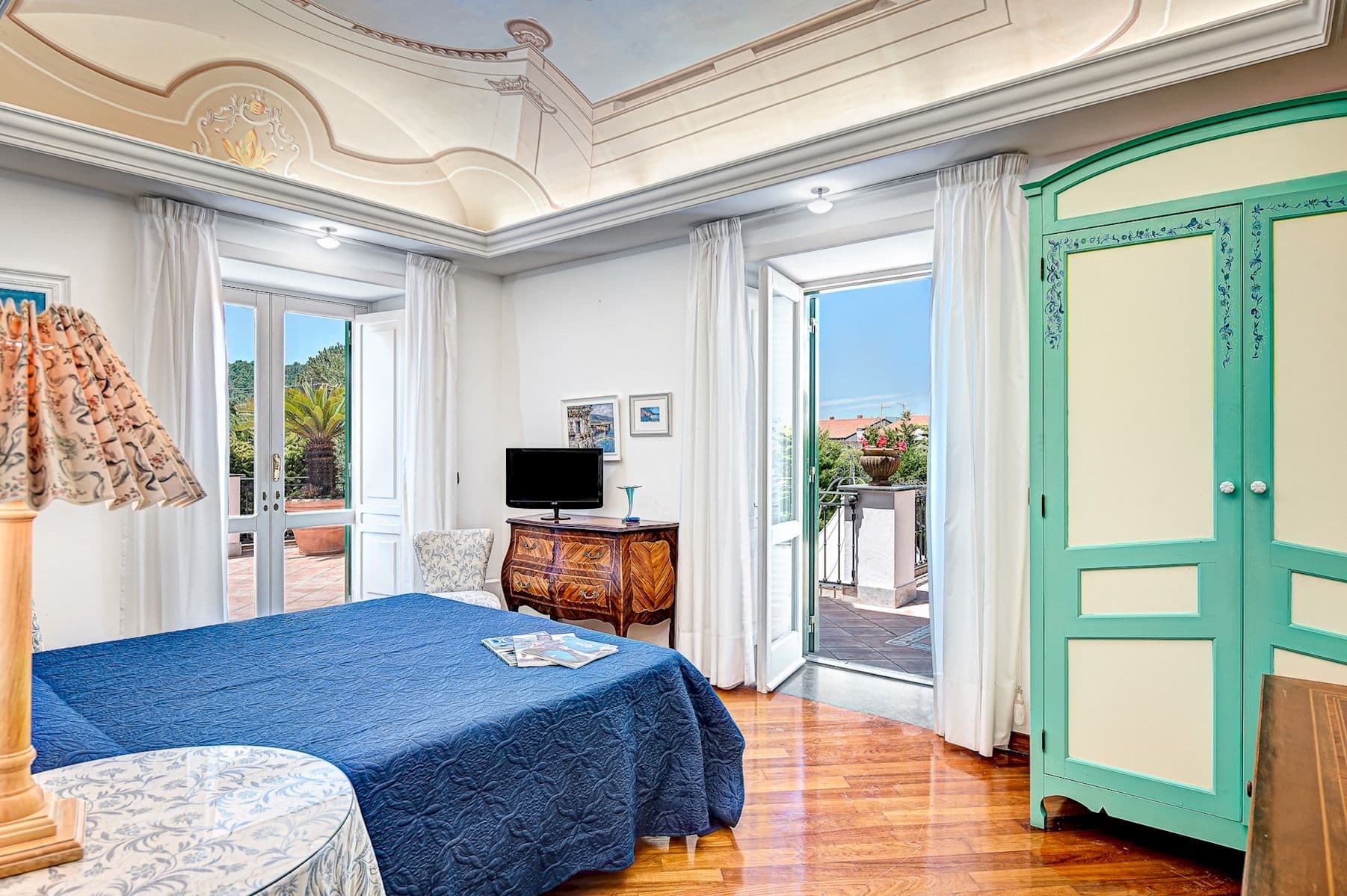 Bedroom with a mint-green wardrobe and blue bedspread.
