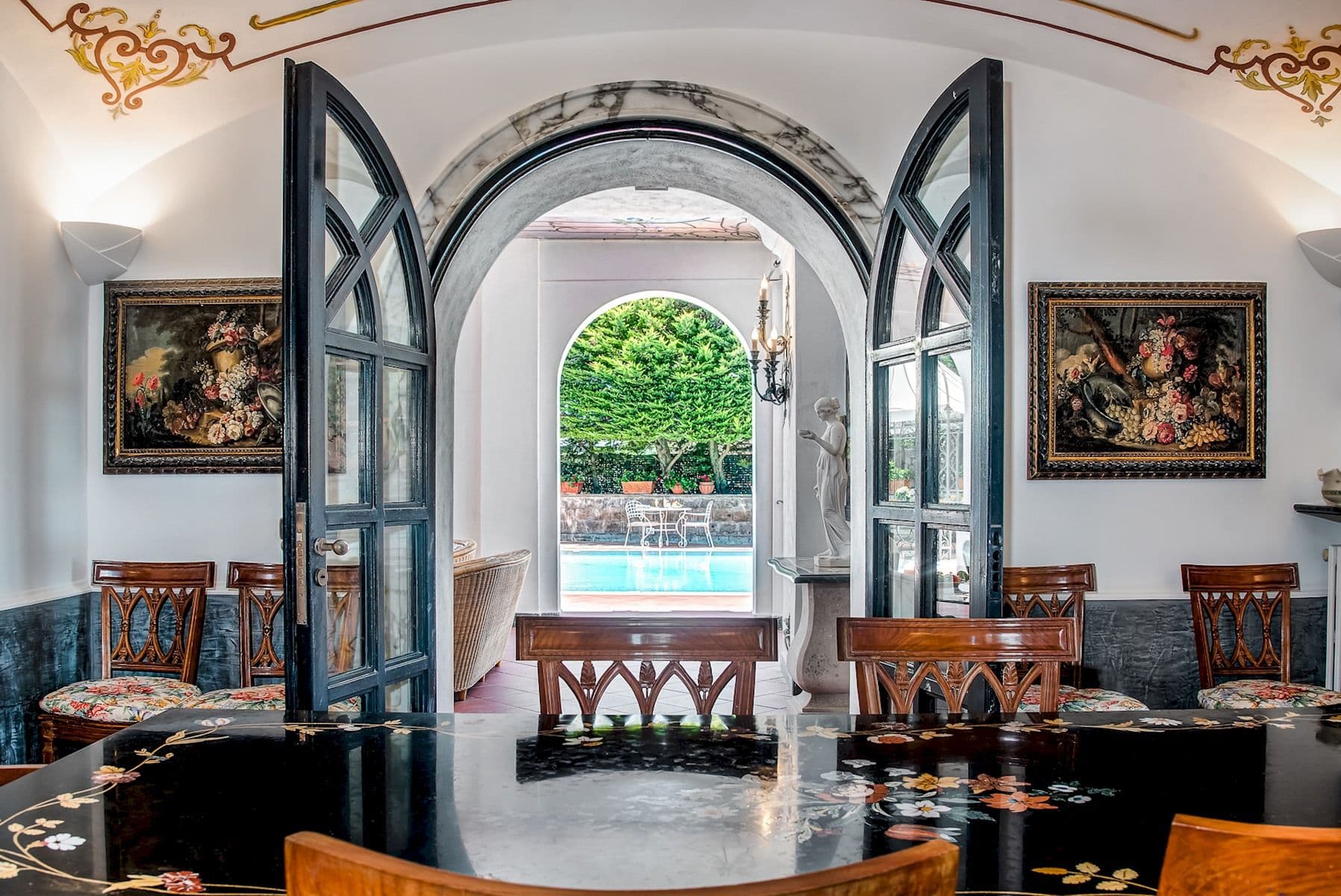 Entrance hall with arched glazed doors opening onto the poolside dining terrace.