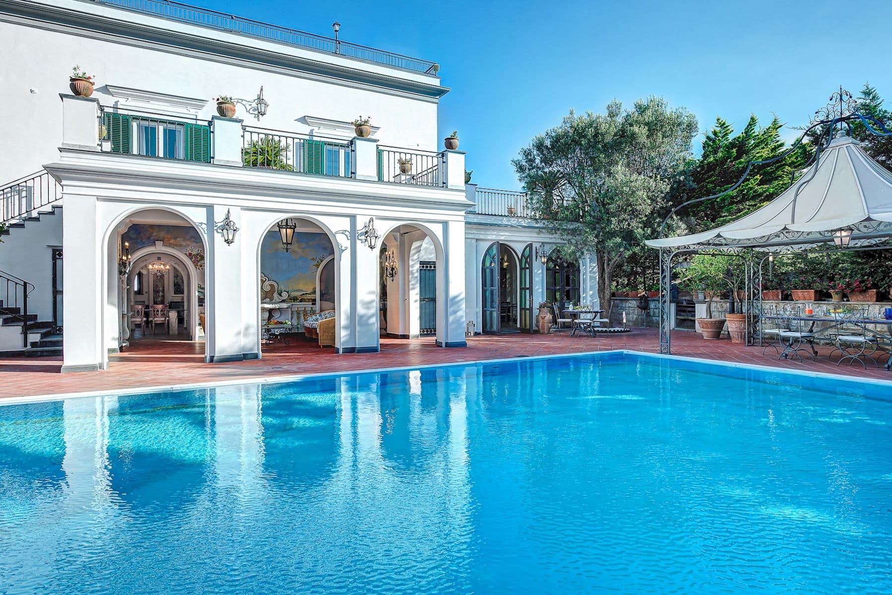 Grand arcaded villa facade reflected in the swimming pool at Painted Palace.