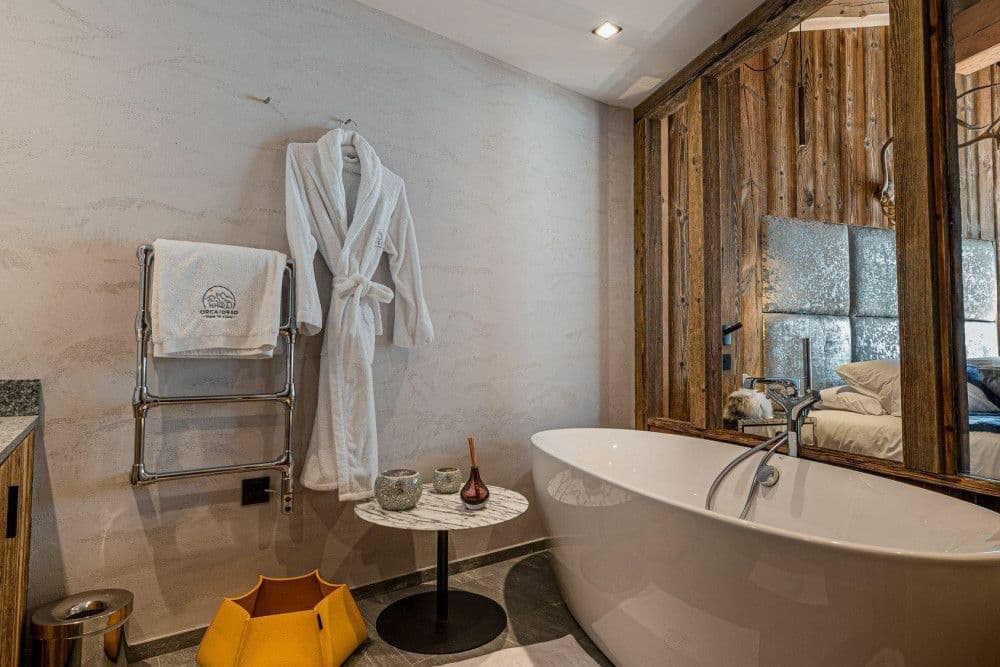 Bathroom with a freestanding tub and robe at Le Fornet 2
