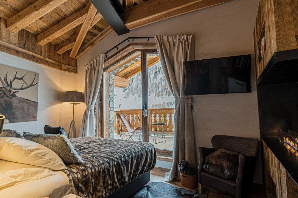 Double bedroom with a fireplace and balcony at Le Fornet 2