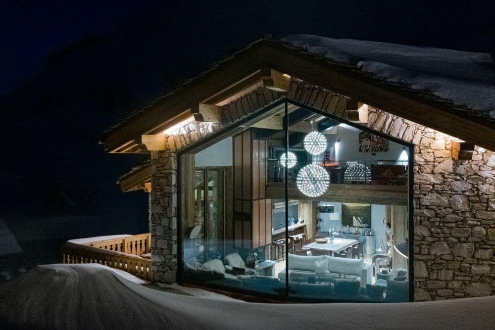 Chalet glowing in the snow at night at Le Fornet 2