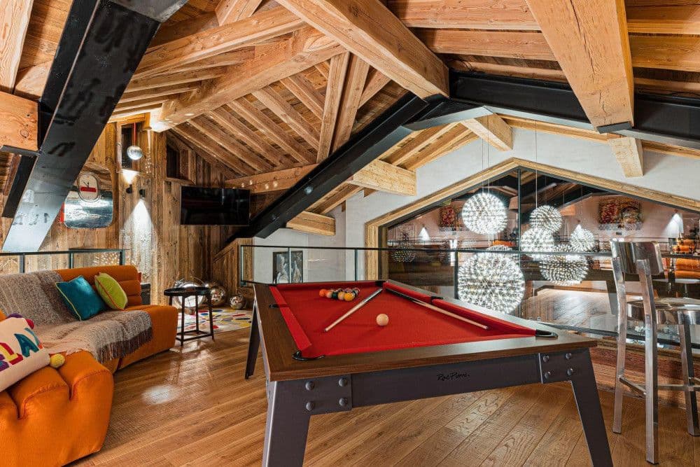 Mezzanine games area with a pool table under a vaulted timber roof at Le Fornet 2