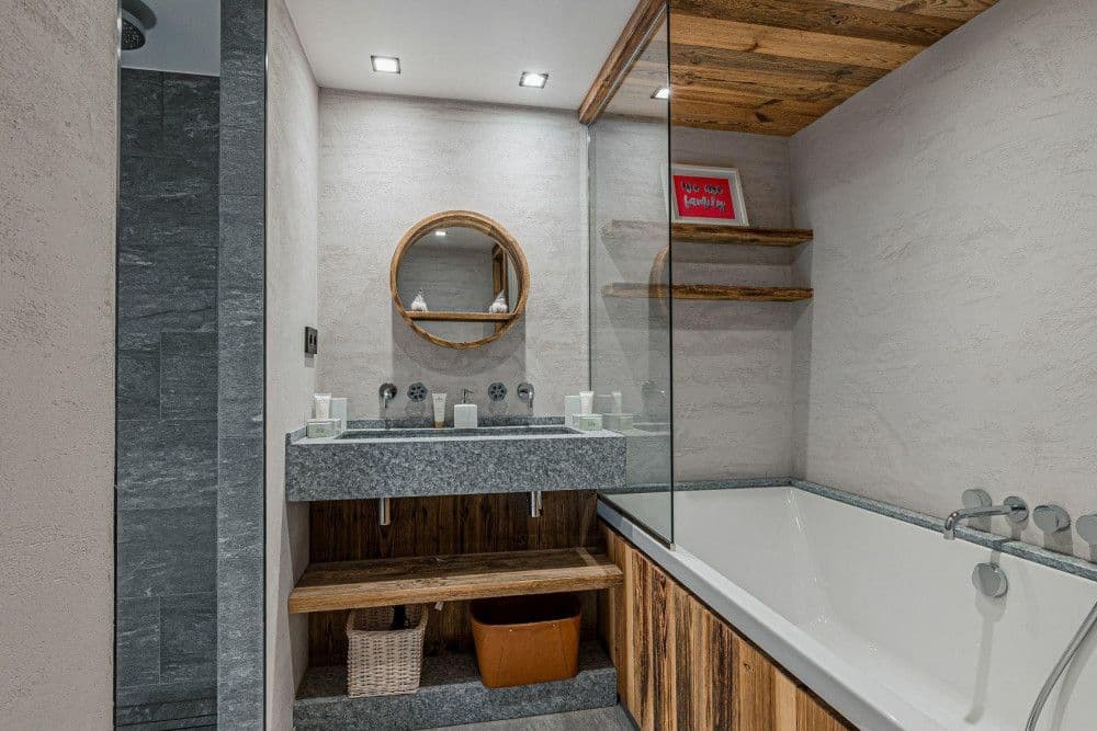 Stone bathroom with a twin vanity and bath at Le Fornet 2