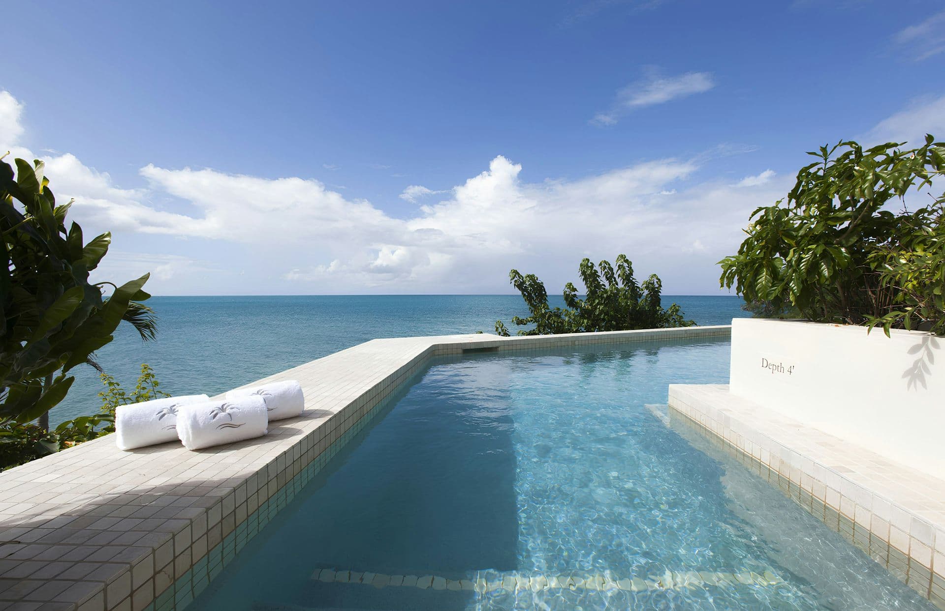 Clifftop pool with rolled towels overlooking the Caribbean Sea at Caribbean Wonder
