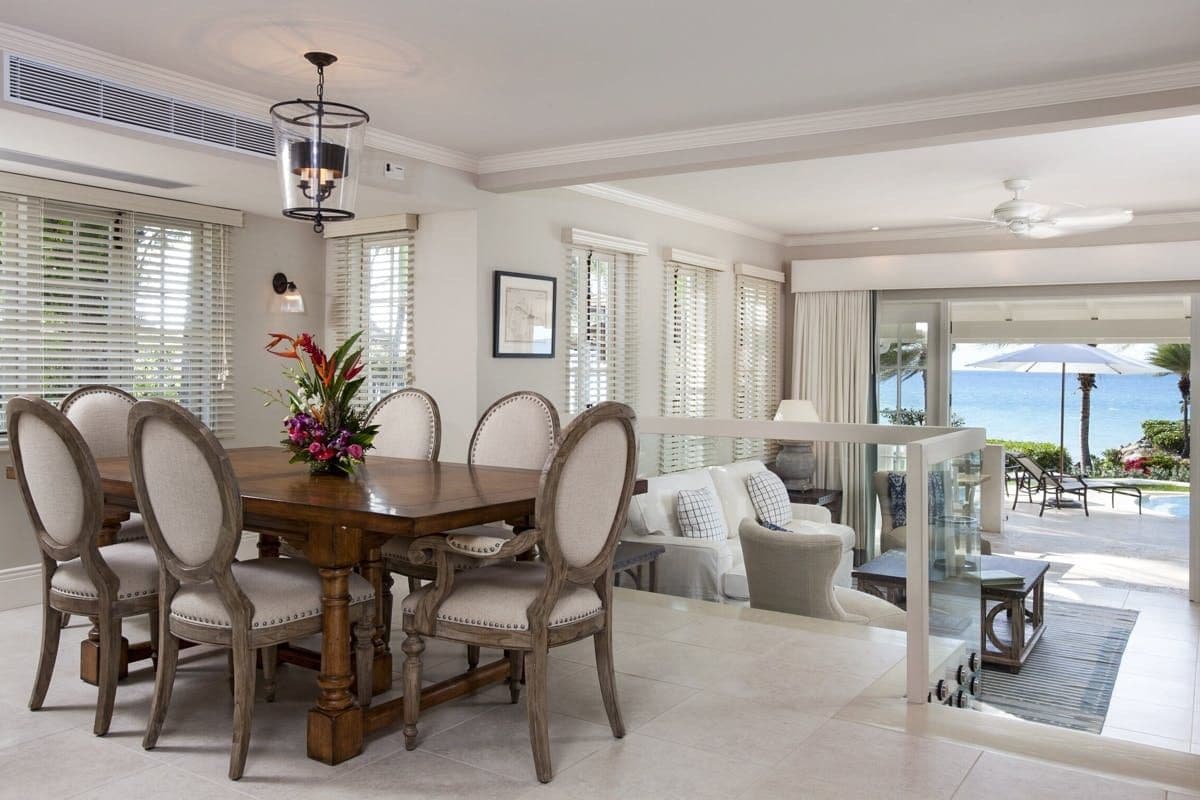 Dining table and open-plan living area with sea view at Caribbean Wonder