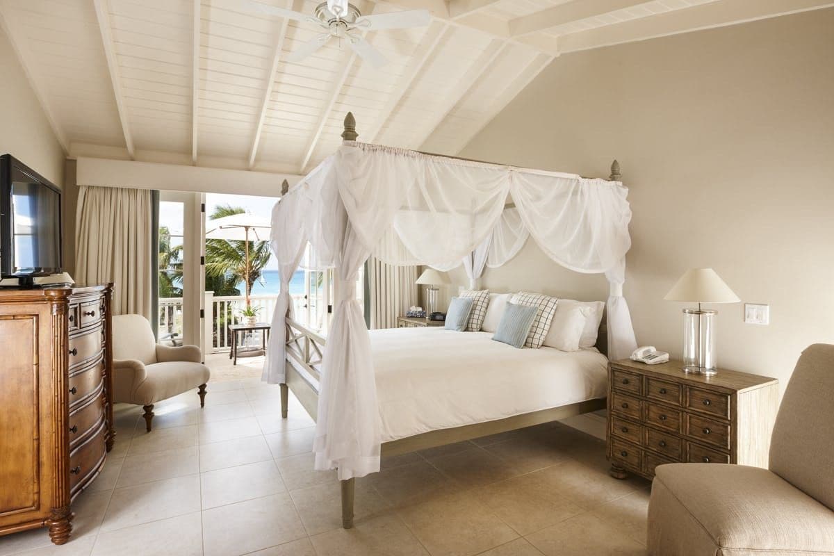 Four-poster master bedroom opening to a sea-view terrace at Caribbean Wonder