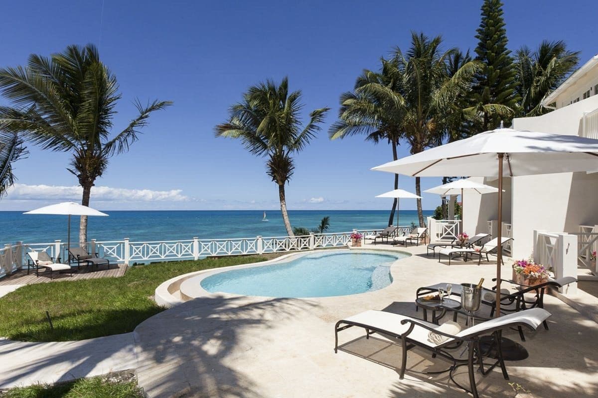 Curved pool framed by palms and loungers at Caribbean Wonder