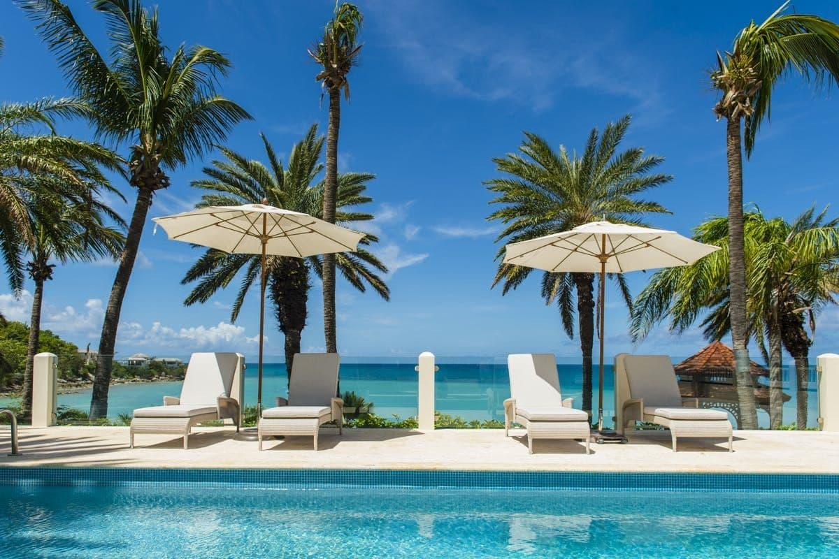 Sun loungers beside the private pool with sea views at Caribbean Wonder