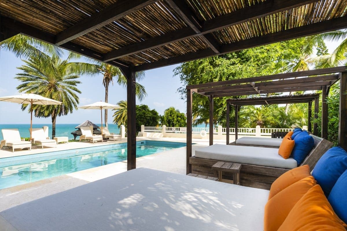 Shaded pergola with a daybed beside the pool at Caribbean Wonder