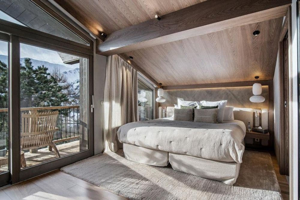 Master bedroom opening to a terrace under a vaulted timber ceiling at Saint Martin de Belleville 12