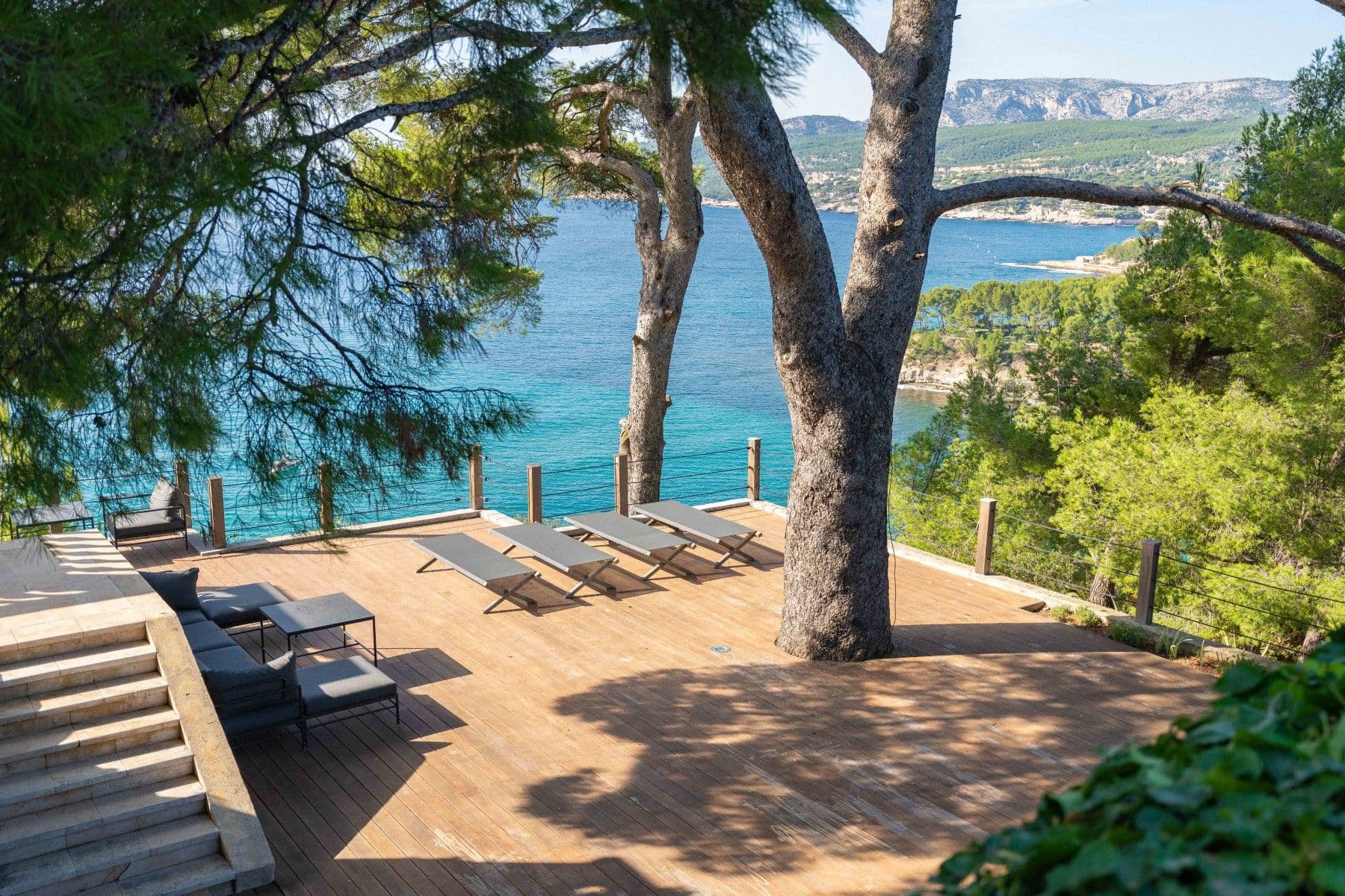 Timber sun deck around a pine looking to Cap Canaille and the bay at Be Our Guest, Cassis, France