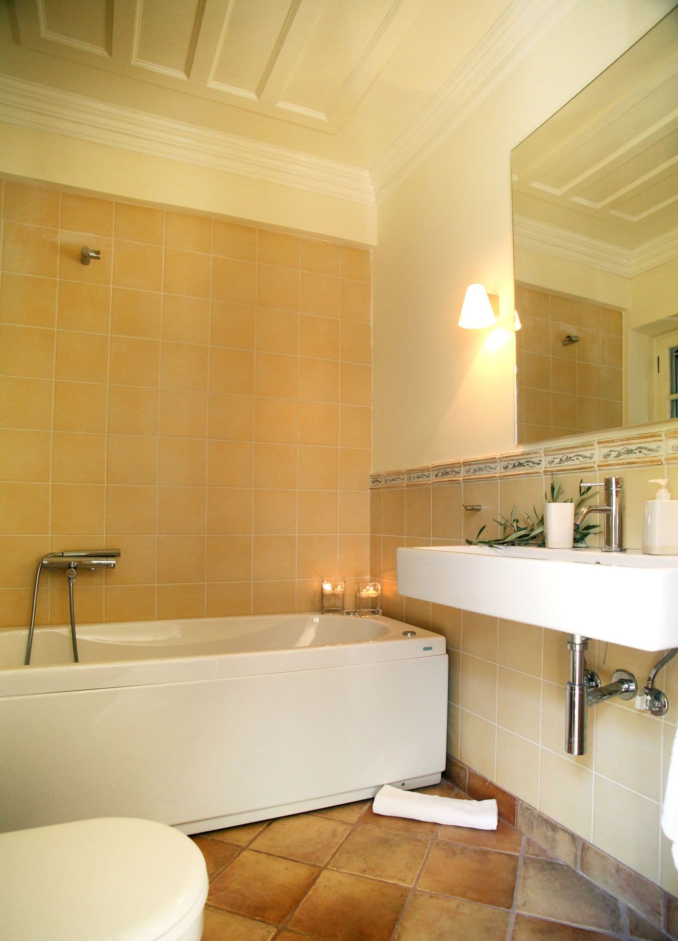 Bathroom with a bathtub and warm terracotta-toned tiling