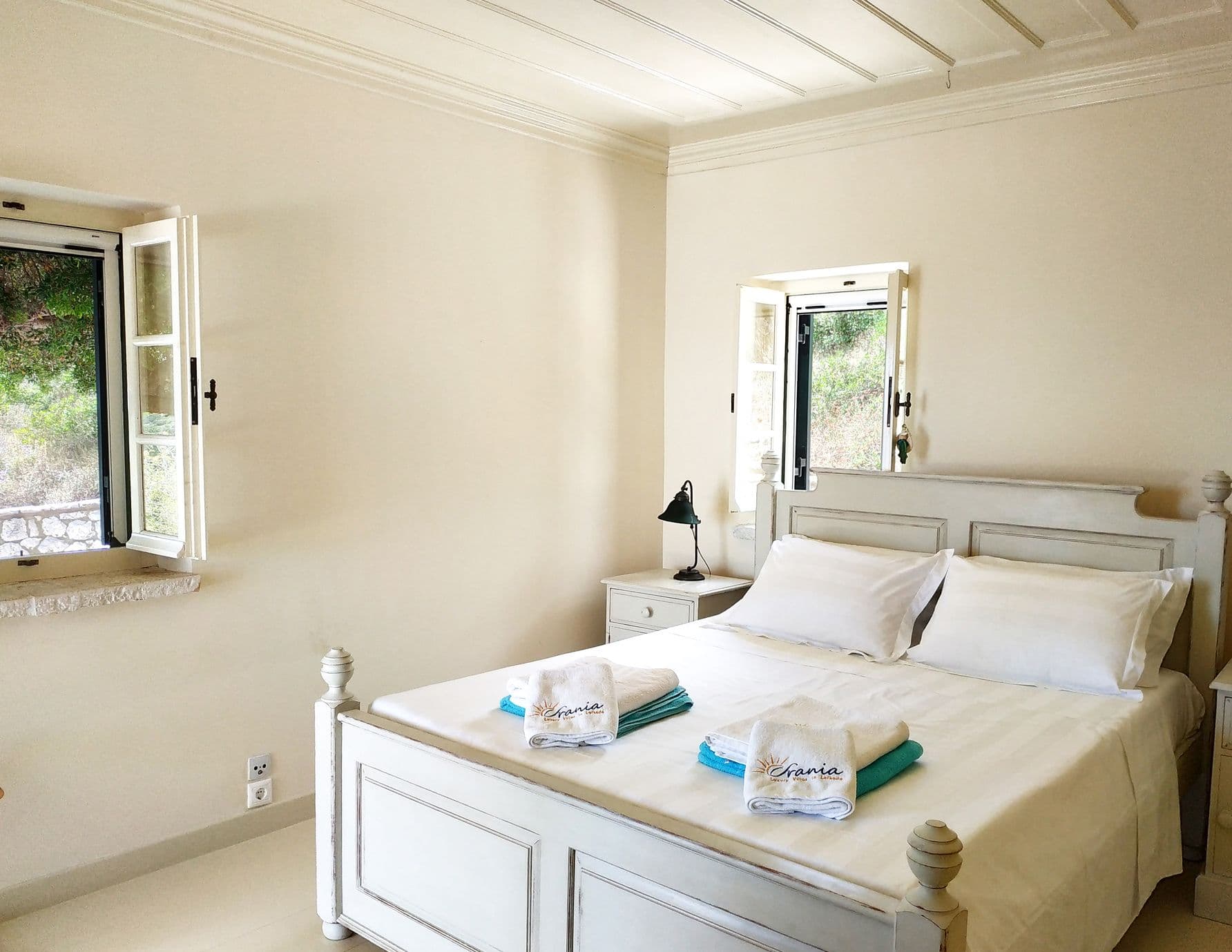 Double bedroom with crisp white linen and a garden-facing window