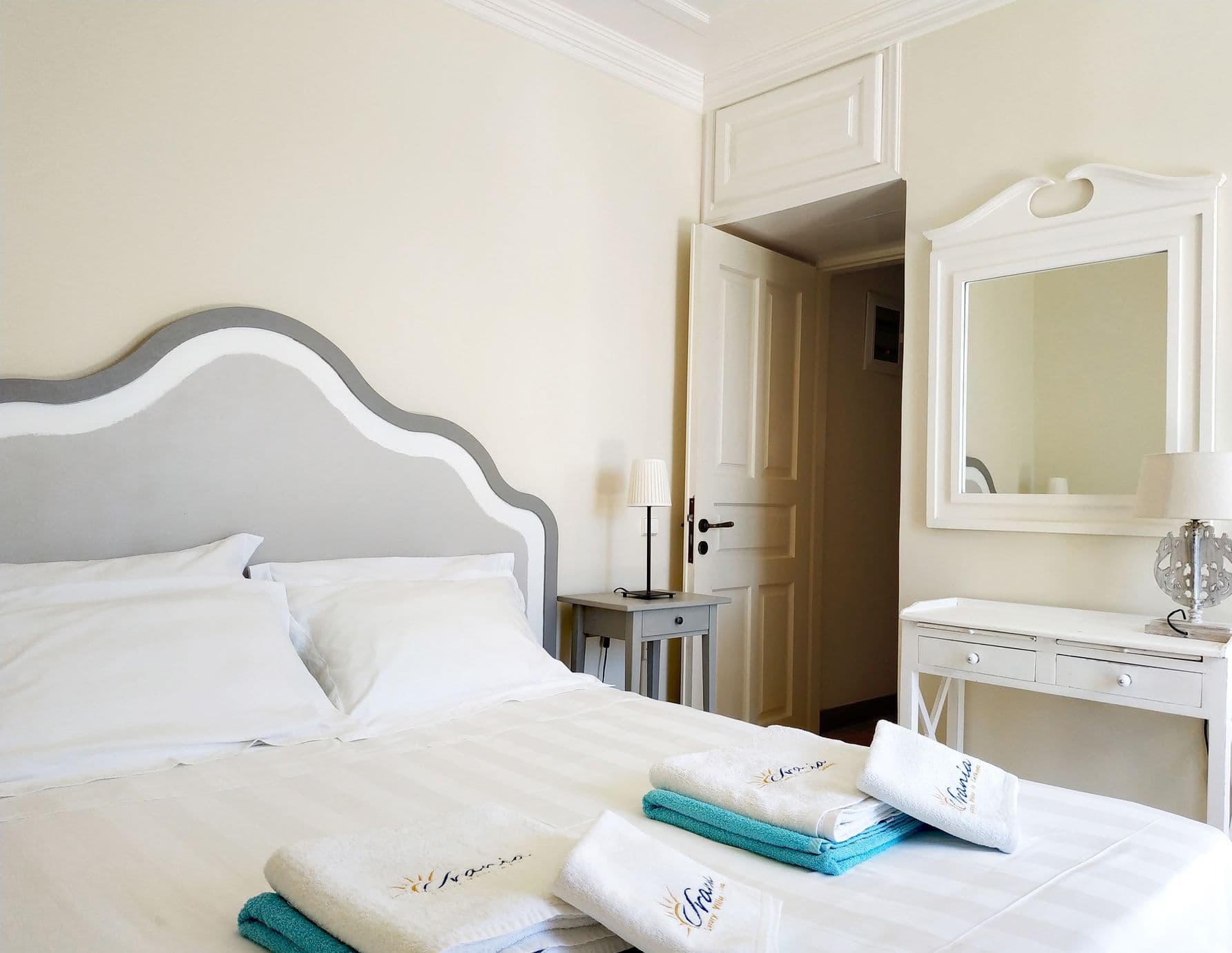 Bedroom with a scalloped grey headboard and matching bedside tables