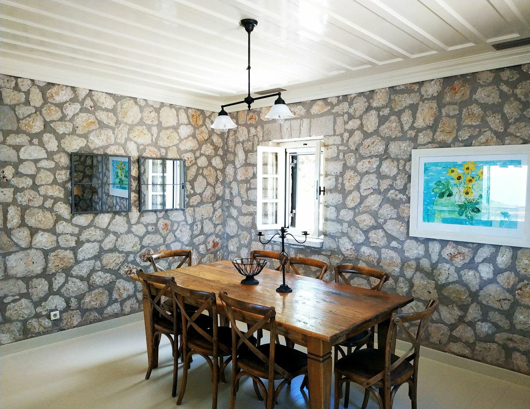 Wooden dining table for eight beneath exposed stone walls