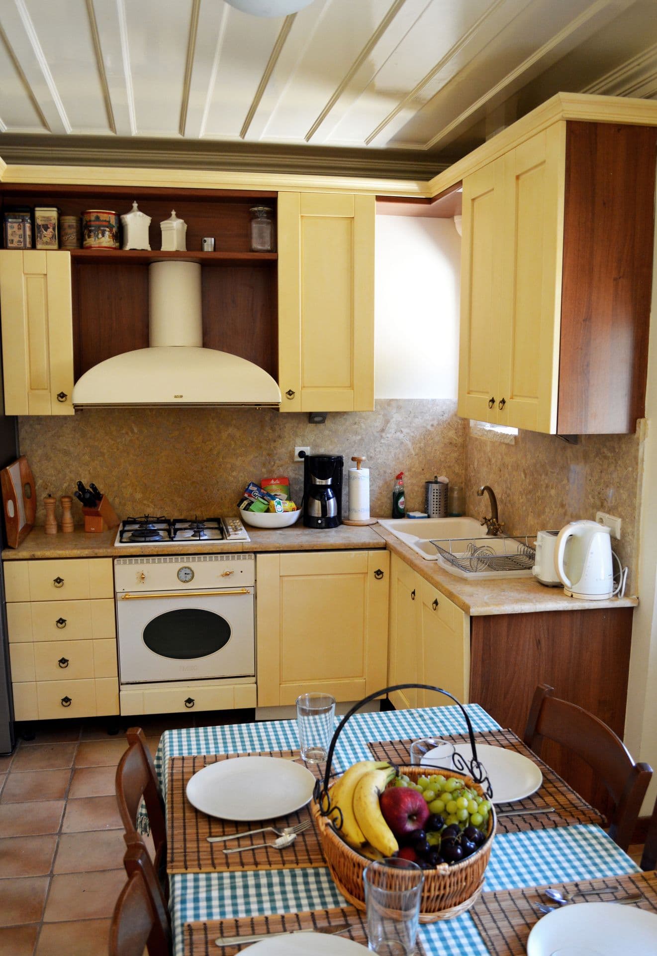 Traditional kitchen with gingham breakfast table and country-style cabinetry