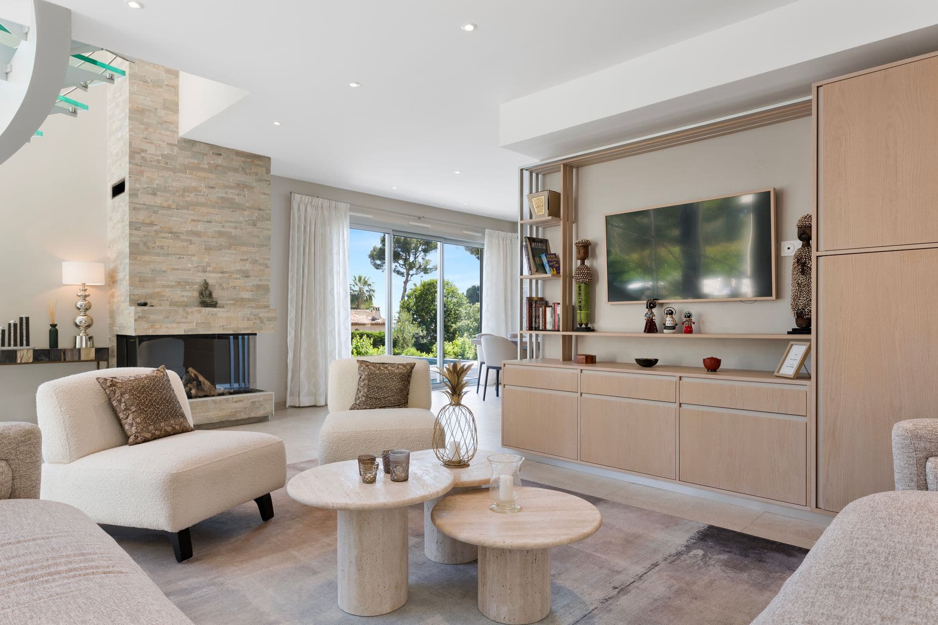Fireside sitting area with a stacked-stone fireplace and garden views at Above Antibes
