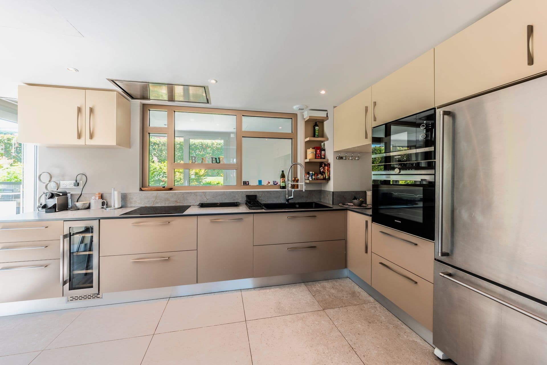 Cream fitted kitchen with stone worktops, wine cooler and integrated appliances at Above Antibes