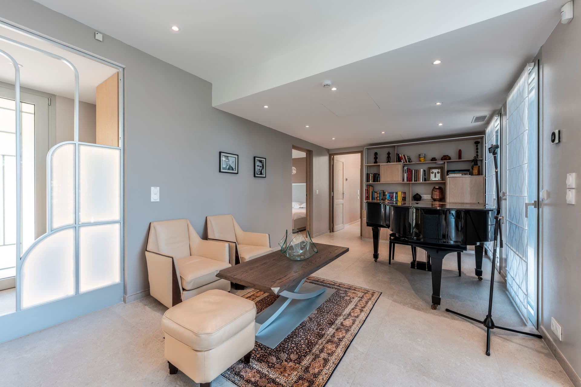 Music room with a grand piano, leather armchairs and a patterned rug at Above Antibes